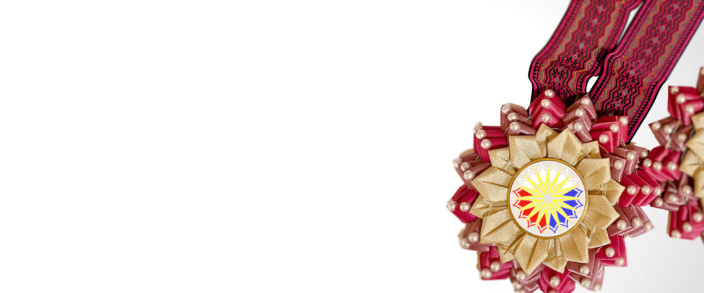 Handcrafted rosette lei centerpiece with gold and pink ribbon and Igorot woven necklace